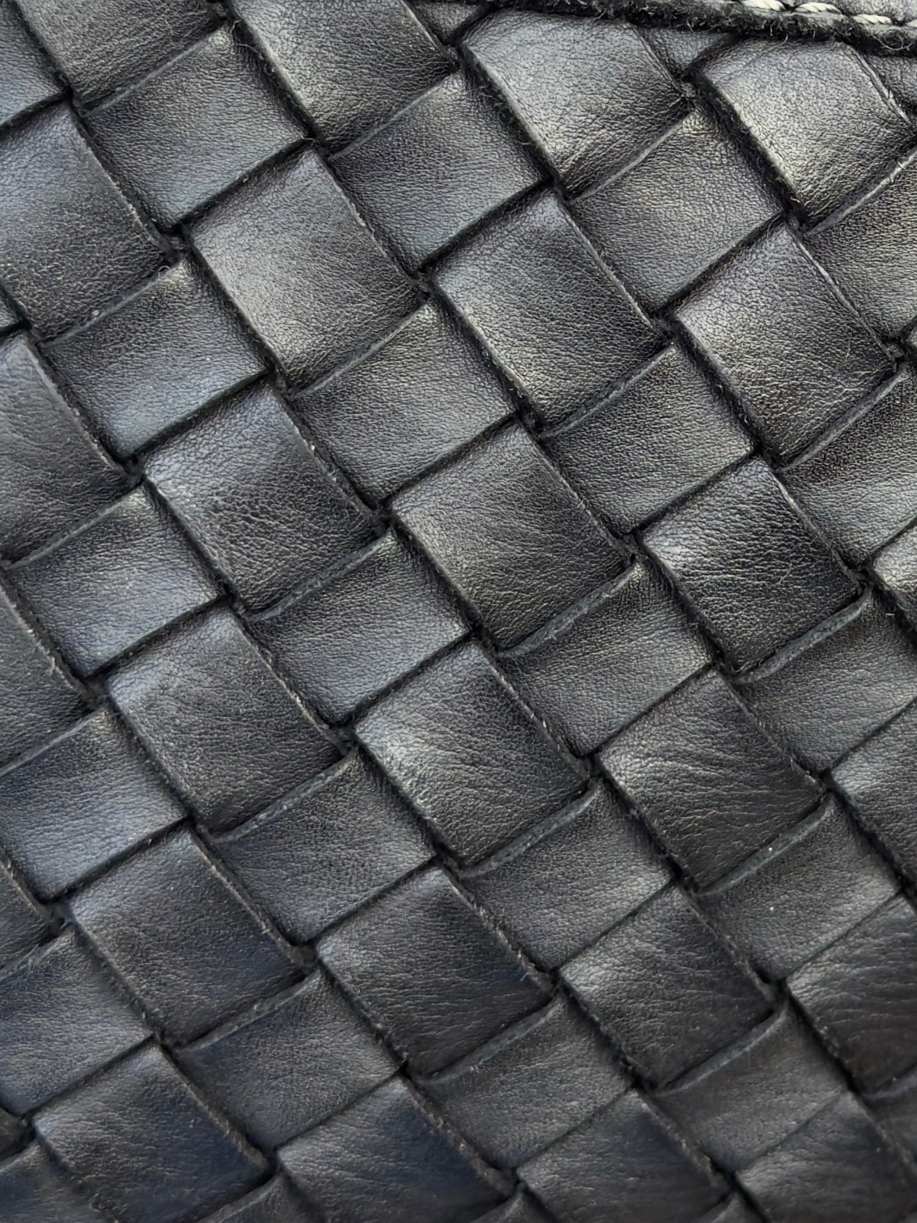 Close-up of a woven black leather texture bag Italian leather shoulder bag with adjustable strap
